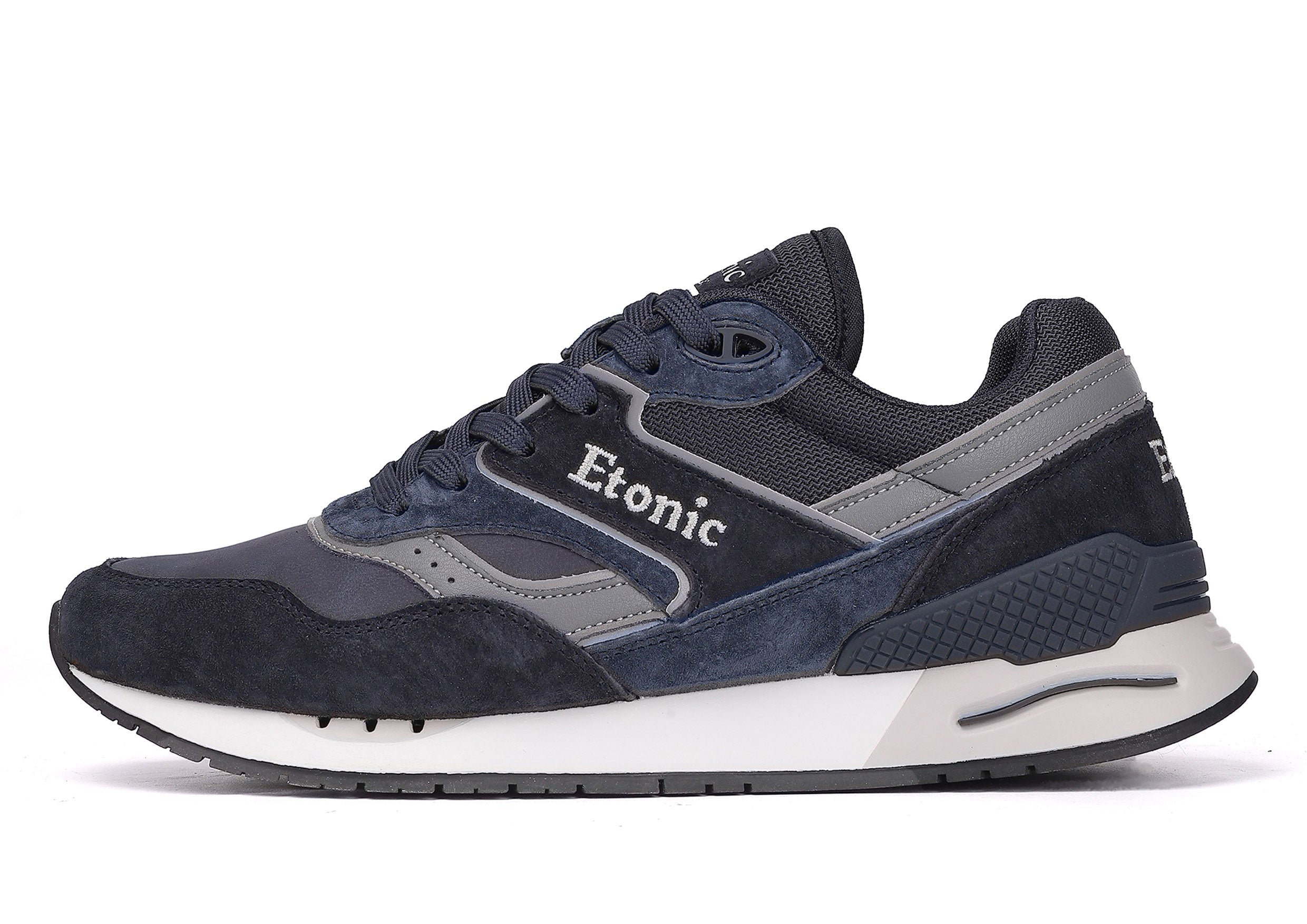 Baskets Etonic Stable Base en nubuck bleu foncé, tissu mesh ton sur ton, daim bleu foncé avec empiècements en cuir gris multicouches, semelle intermédiaire blanche et semelle extérieure inférieure bleu foncé.