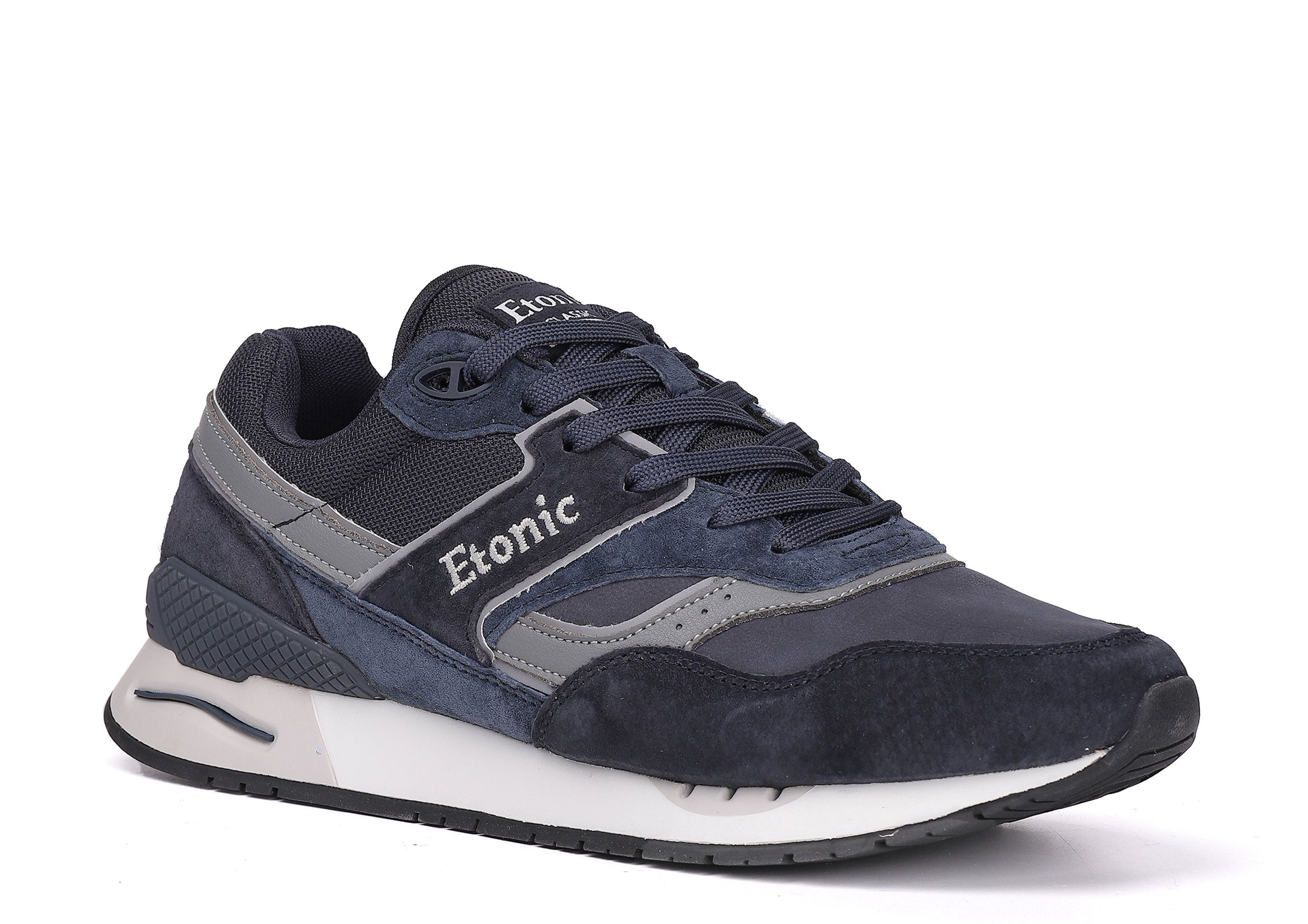 Baskets Etonic Stable Base en nubuck bleu foncé, tissu mesh ton sur ton, daim bleu foncé avec empiècements en cuir gris multicouches, semelle intermédiaire blanche et semelle extérieure inférieure bleu foncé.