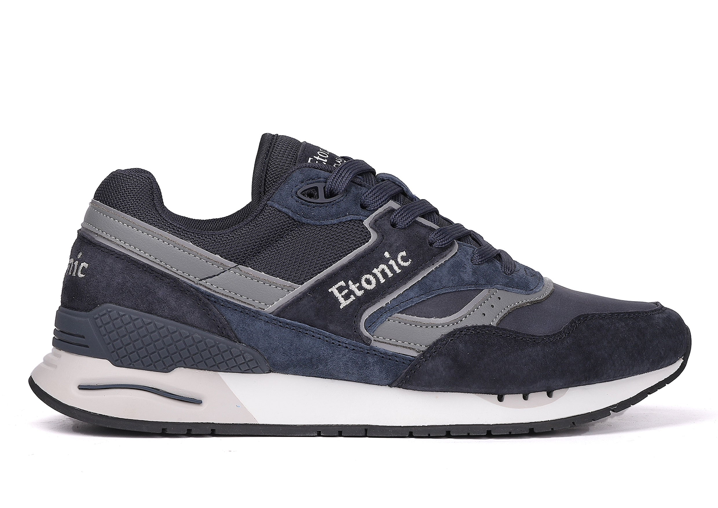 Baskets Etonic Stable Base en nubuck bleu foncé, tissu mesh ton sur ton, daim bleu foncé avec empiècements en cuir gris multicouches, semelle intermédiaire blanche et semelle extérieure inférieure bleu foncé.