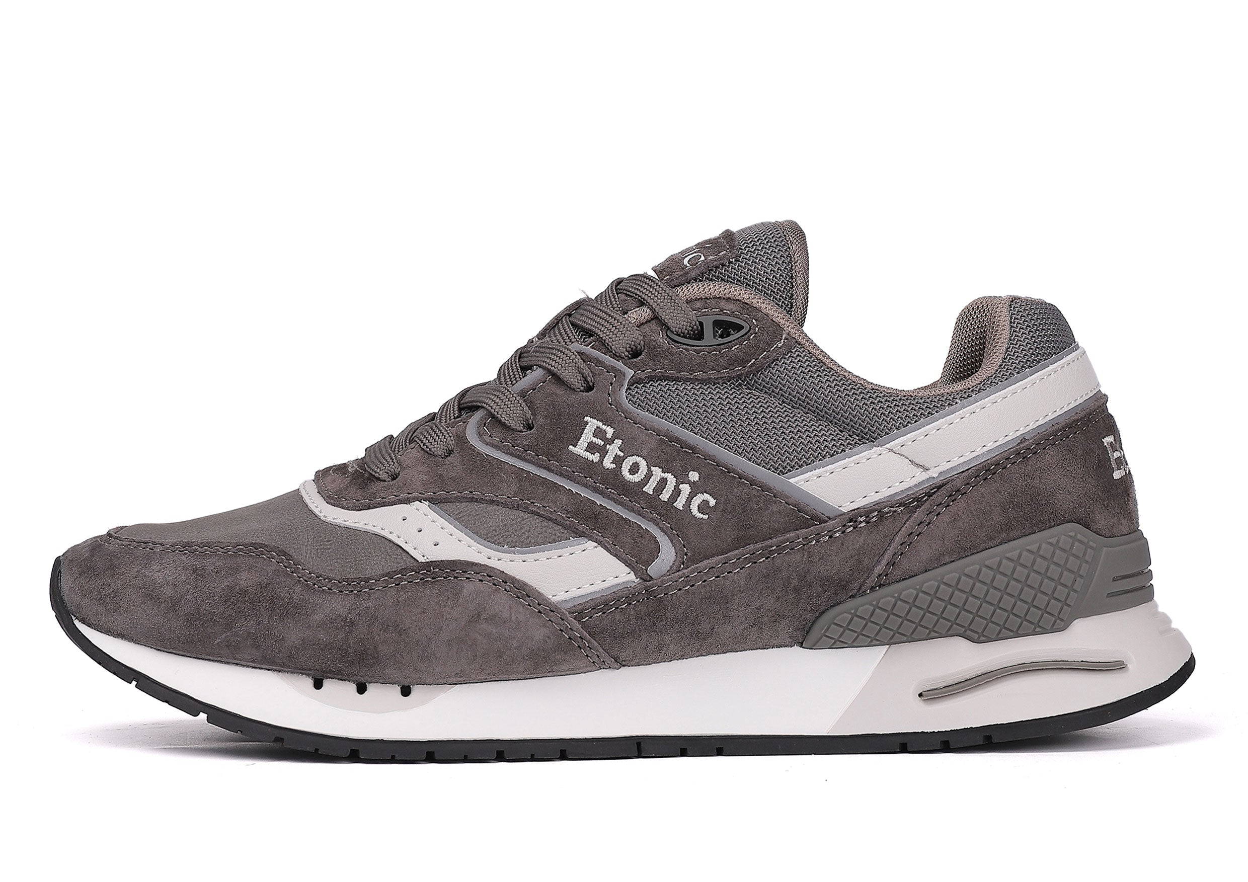 Baskets Etonic Stable Base en nubuck gris foncé, tissu mesh ton sur ton, daim gris foncé avec empiècements en cuir blanc multicouches, semelle intermédiaire blanche et semelle extérieure inférieure gris foncé.