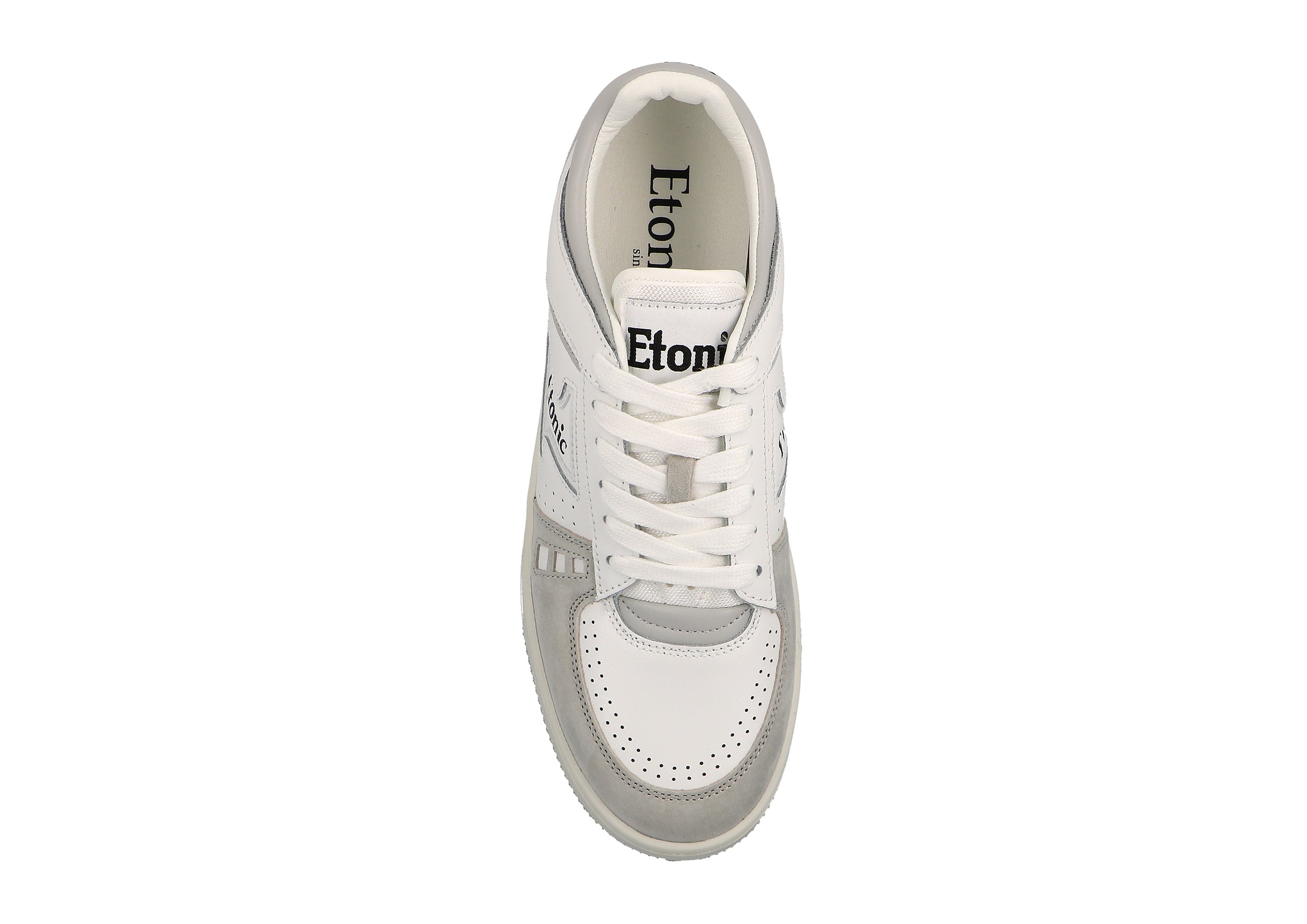 Baskets Etonic B509 en cuir blanc, daim gris clair, détails noirs et semelle extérieure blanc cassé.