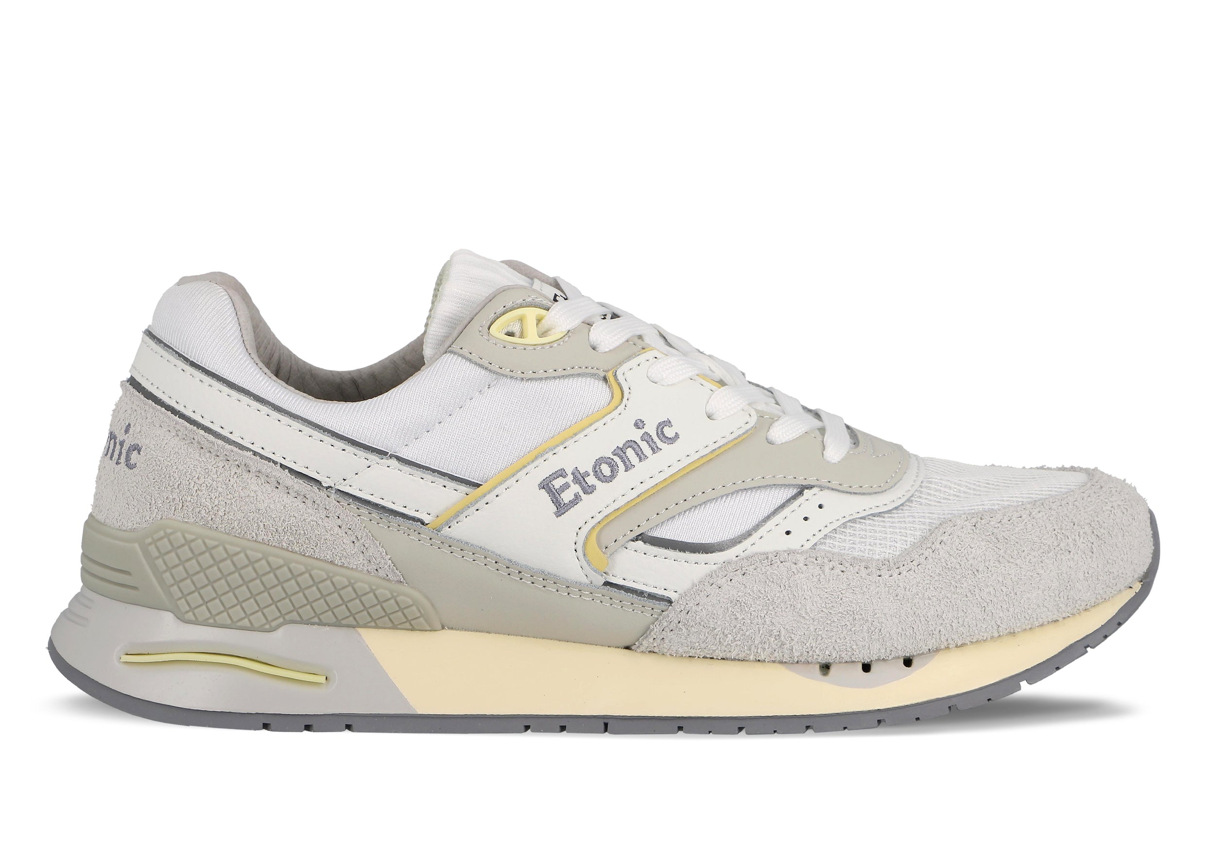 Sneakers Etonic Stable Base in tessuto a rete bianco, pelle scamosciata grigio ghiaccio con inserti in pelle bianca multistrato, dettagli grigio fumo e gialli, intersuola beige e suola inferiore grigio fumo.