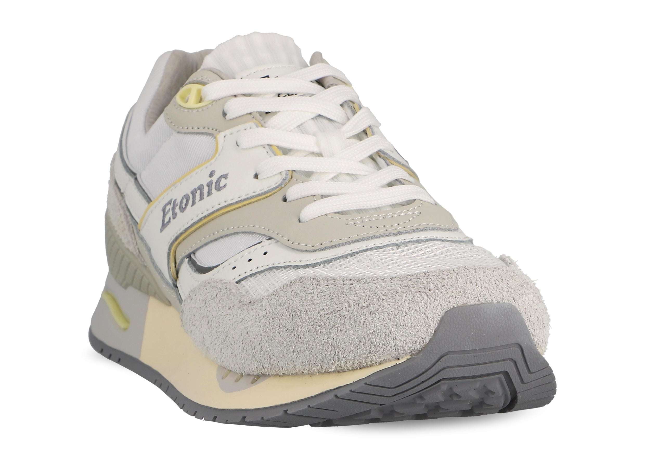 Sneakers Etonic Stable Base in tessuto a rete bianco, pelle scamosciata grigio ghiaccio con inserti in pelle bianca multistrato, dettagli grigio fumo e gialli, intersuola beige e suola inferiore grigio fumo.