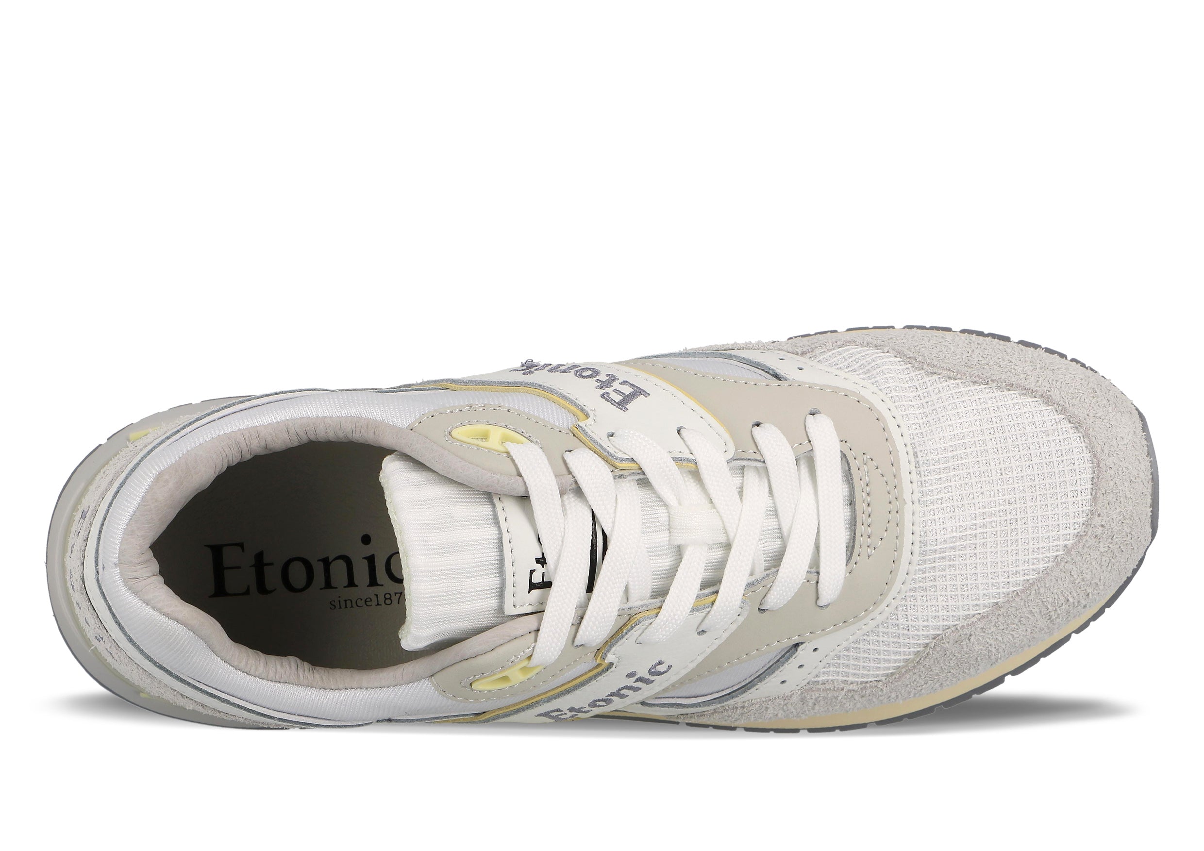 Sneakers Etonic Stable Base in tessuto a rete bianco, pelle scamosciata grigio ghiaccio con inserti in pelle bianca multistrato, dettagli grigio fumo e gialli, intersuola beige e suola inferiore grigio fumo.