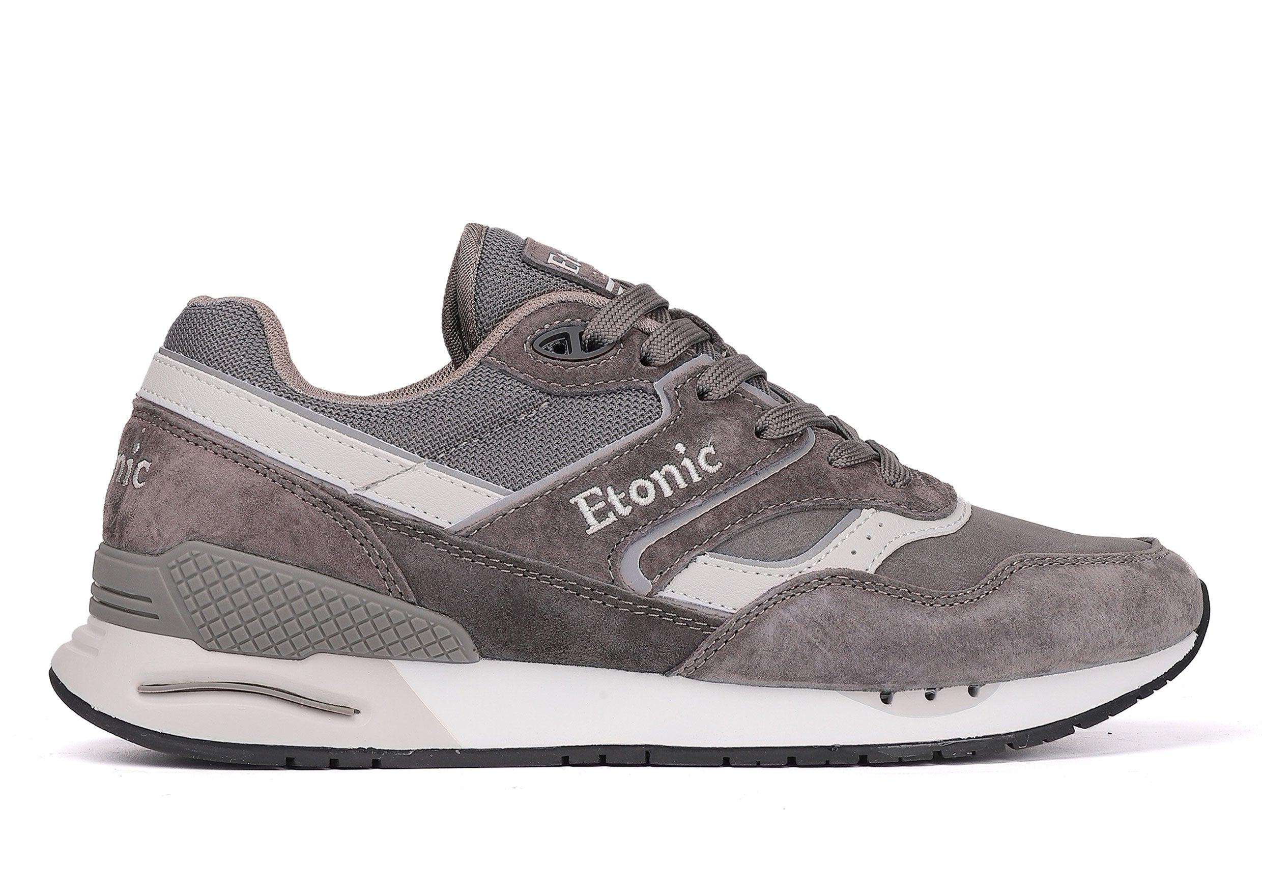 Sneakers Etonic Stable Base in nabuk grigio scuro, tessuto a rete tono su tono, pelle scamosciata grigio scuro con inserti in pelle bianca multistrato, intersuola bianca e suola inferiore grigio scuro.