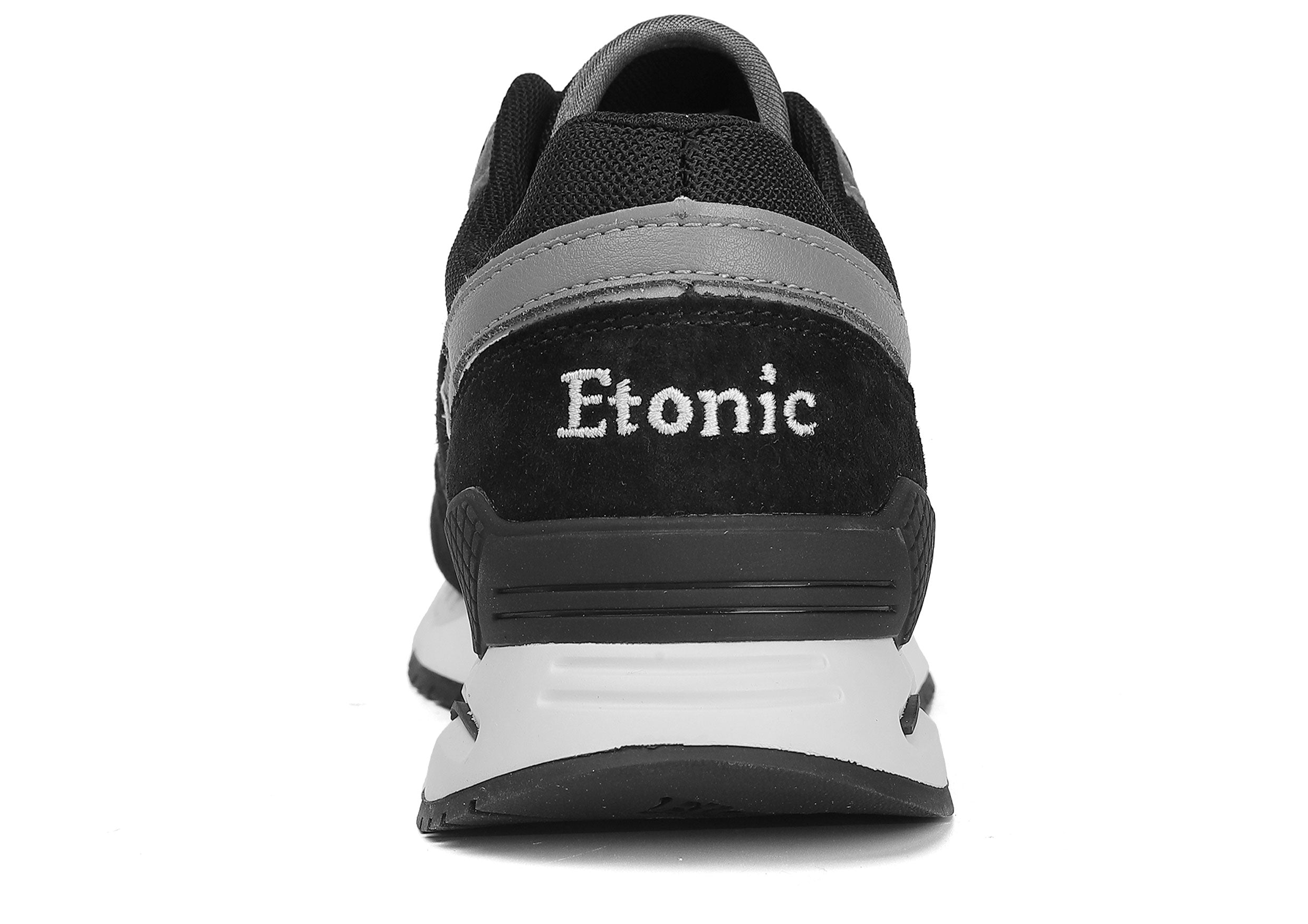 Sneakers Etonic Stable Base in nabuk nero, tessuto a rete tono su tono, pelle scamosciata nera con inserti in pelle multistrato grigio scuro, intersuola bianca e suola inferiore nera.