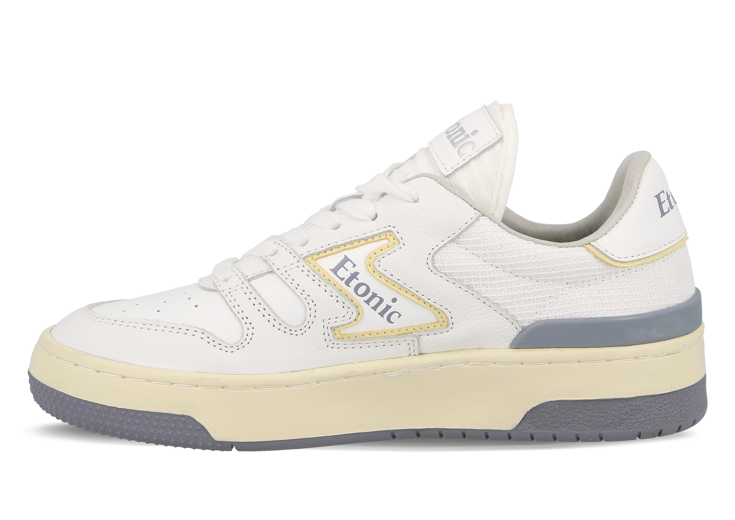 Baskets Etonic B481 en cuir blanc, mesh blanc, détails jaune et vert gris fumé avec semelle intermédiaire beige et semelle extérieure inférieure gris fumé.